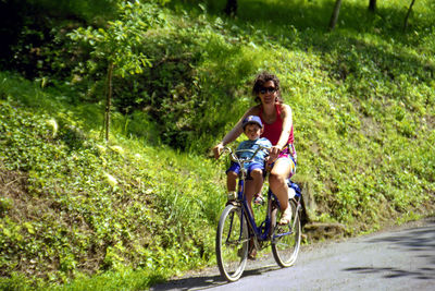 Young woman riding bicycle on plants