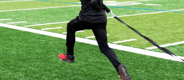 Low section of man playing soccer on field