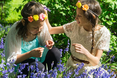 Young woman holding flowers in park