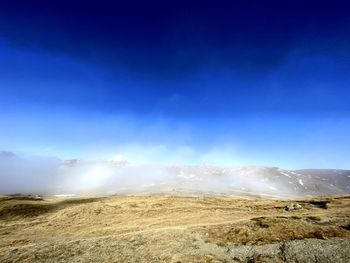 Scenic view of landscape against blue sky