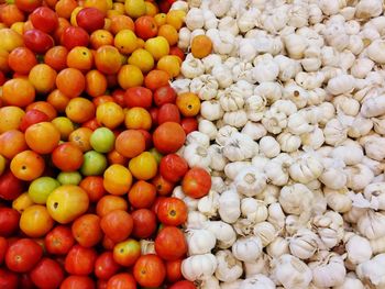 Full frame shot of garlic and tomatoes for sale at market