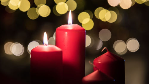 Close-up of illuminated candles against christmas lights