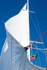 Low angle view of sailboat sailing on blue sky