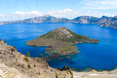 Scenic view of sea and mountains against sky