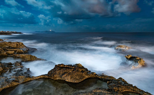 Scenic view of rocks in sea against sky