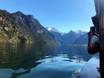 Scenic view of lake by mountains against blue sky