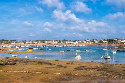 Scenic view of small harbor in brittany, france at low sea tide against dramatic sky