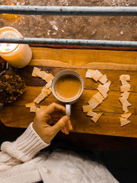 High angle view of hand holding coffee cup