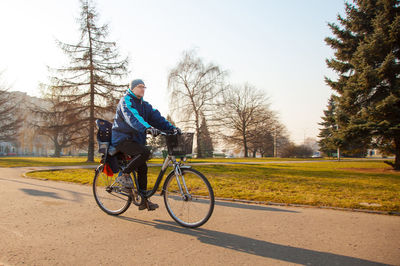 Man riding bicycle on road at park