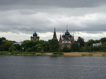 View of river by building against sky
