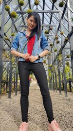 Portrait of young woman standing against plants