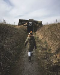 Rear view of man walking on field