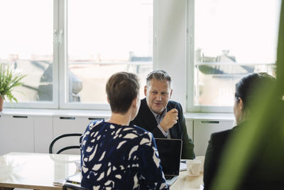 Business people discussing at table in office