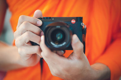 Midsection of man holding camera