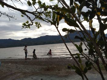 People on beach against sky