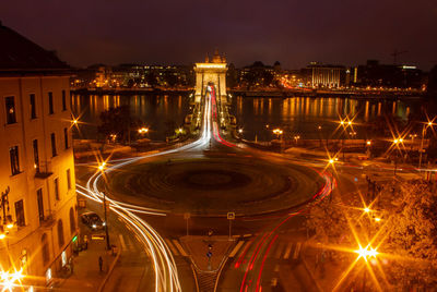Illuminated light trails on road against sky at night