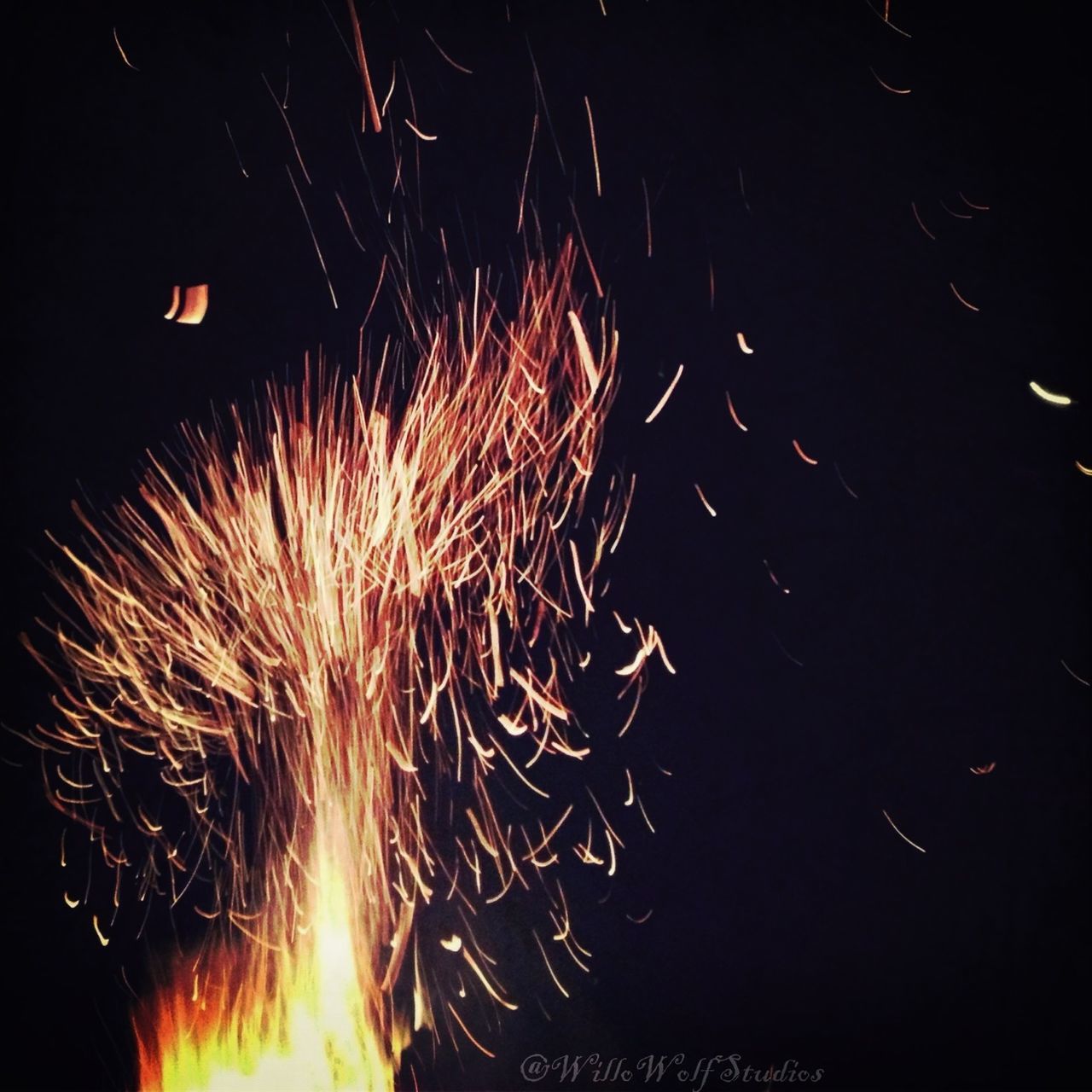 night, illuminated, long exposure, glowing, fire - natural phenomenon, motion, celebration, firework display, exploding, burning, sparks, firework - man made object, dark, blurred motion, low angle view, arts culture and entertainment, heat - temperature, event, light - natural phenomenon, flame