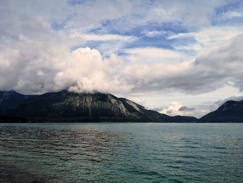 Scenic view of sea by mountains against sky