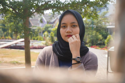 Portrait of young woman sitting outdoors