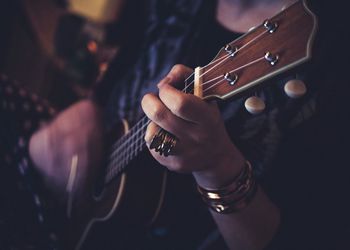 Midsection of person playing guitar