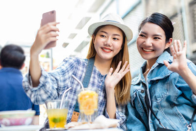 Portrait of smiling young woman using laptop