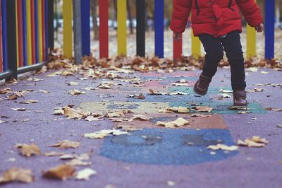 Low section of child playing hopscotch at playground during autumn