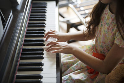 High angle view of girl playing piano at home