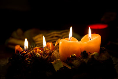 Close-up of illuminated candles in darkroom