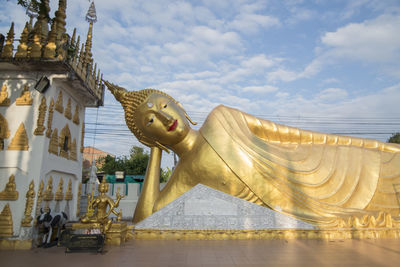 Sculpture of statues outside building against sky