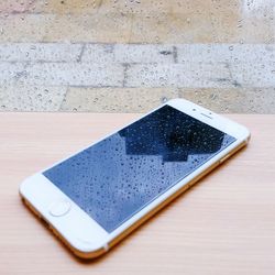 Close-up of wet mobile phone on table