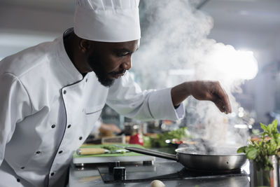 Midsection of man preparing food in kitchen