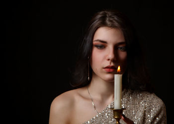 Portrait of a beautiful young woman over black background