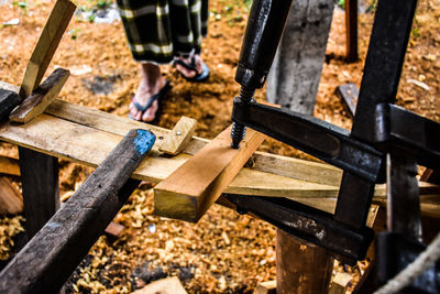 Low section of man relaxing on wooden log