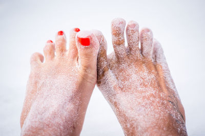 Low section of woman relaxing on wet shore