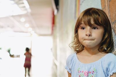 Close-up of girl standing against wall