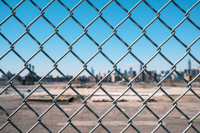 Close-up of chainlink fence against sky