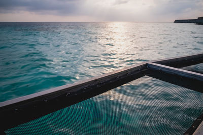 Swimming pool by sea against sky