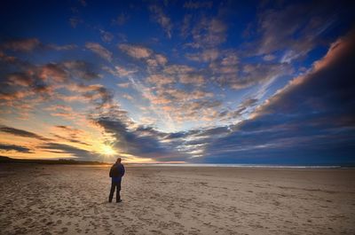 Scenic view of beach against cloudy sky