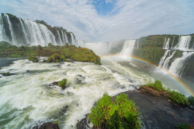 Scenic view of waterfall against sky