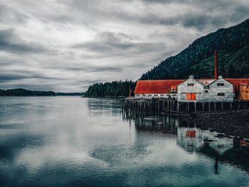 Scenic view of lake by buildings against sky