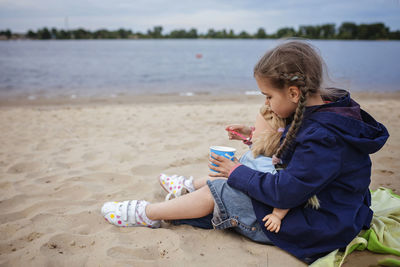 Girl sitting on shore at beach