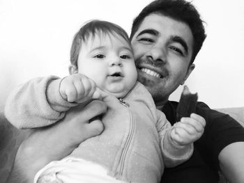 Portrait of father and daughter against wall