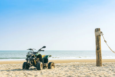 Vintage green atv on the sandy beach. quad atv all terrain vehicle parked on beach, 