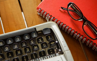 High angle view of typewriter by book on table