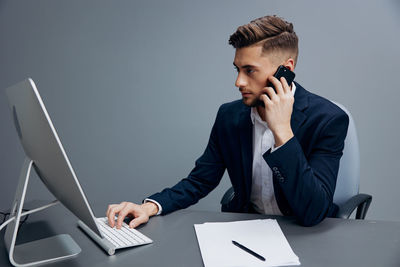 Side view of young man using mobile phone