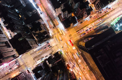 High angle view of illuminated street amidst buildings in city at night