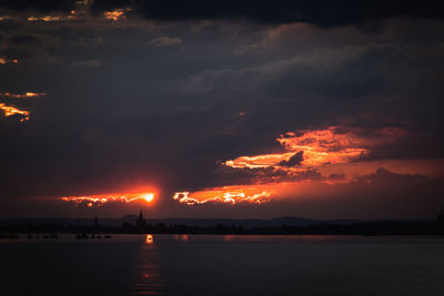 Scenic view of sea against dramatic sky during sunset