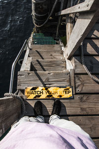 Low section of man standing on wooden steps