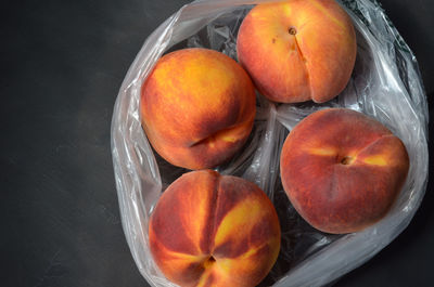 Overhead view of peaches in plastic grocery store bag