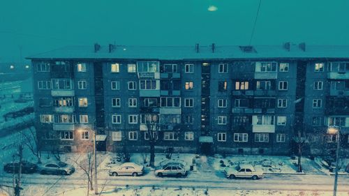 Cars on street by buildings against sky